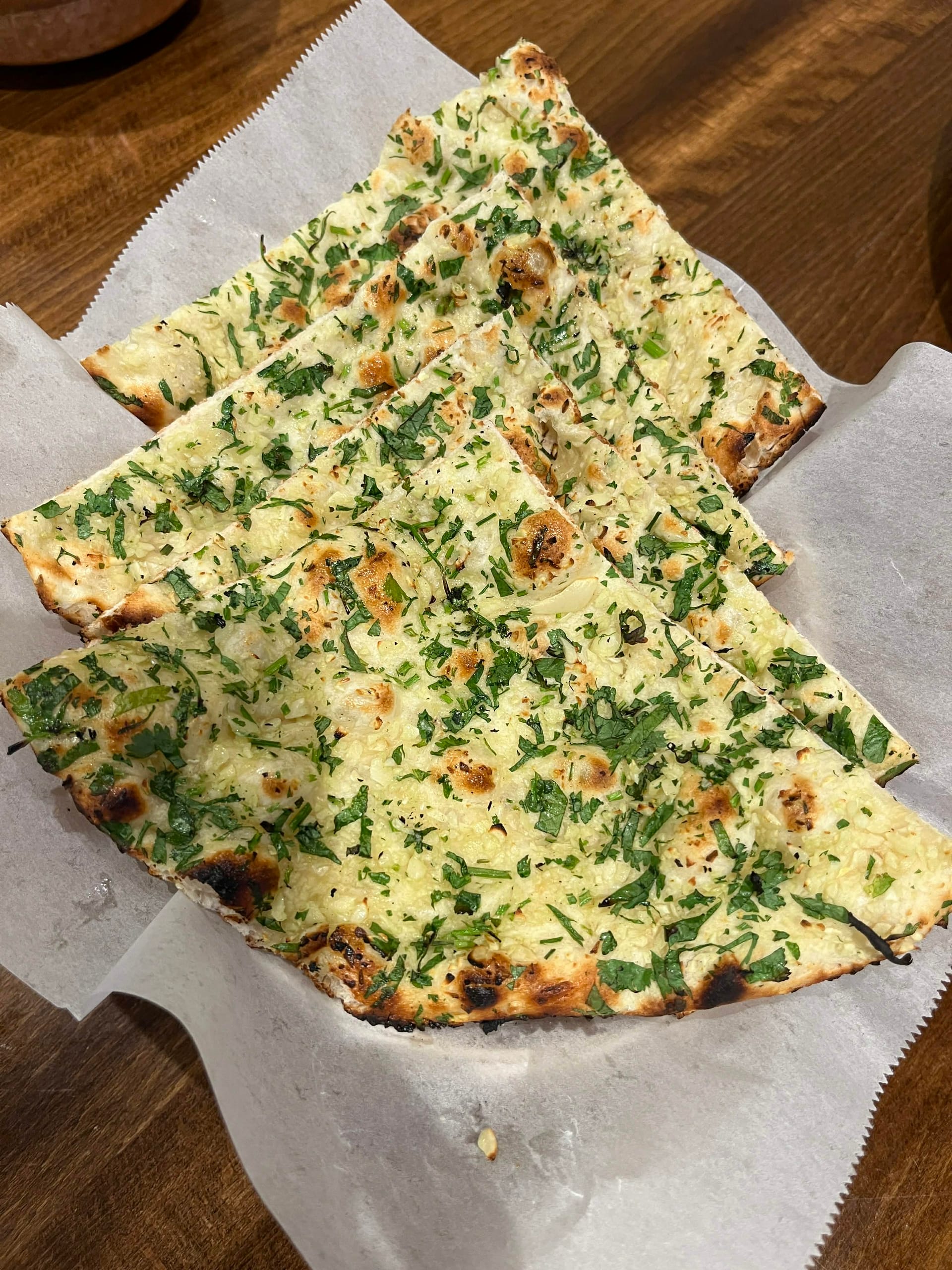 Soft and fluffy Indian bread infused with garlic and herbs, perfect for scooping up curries.